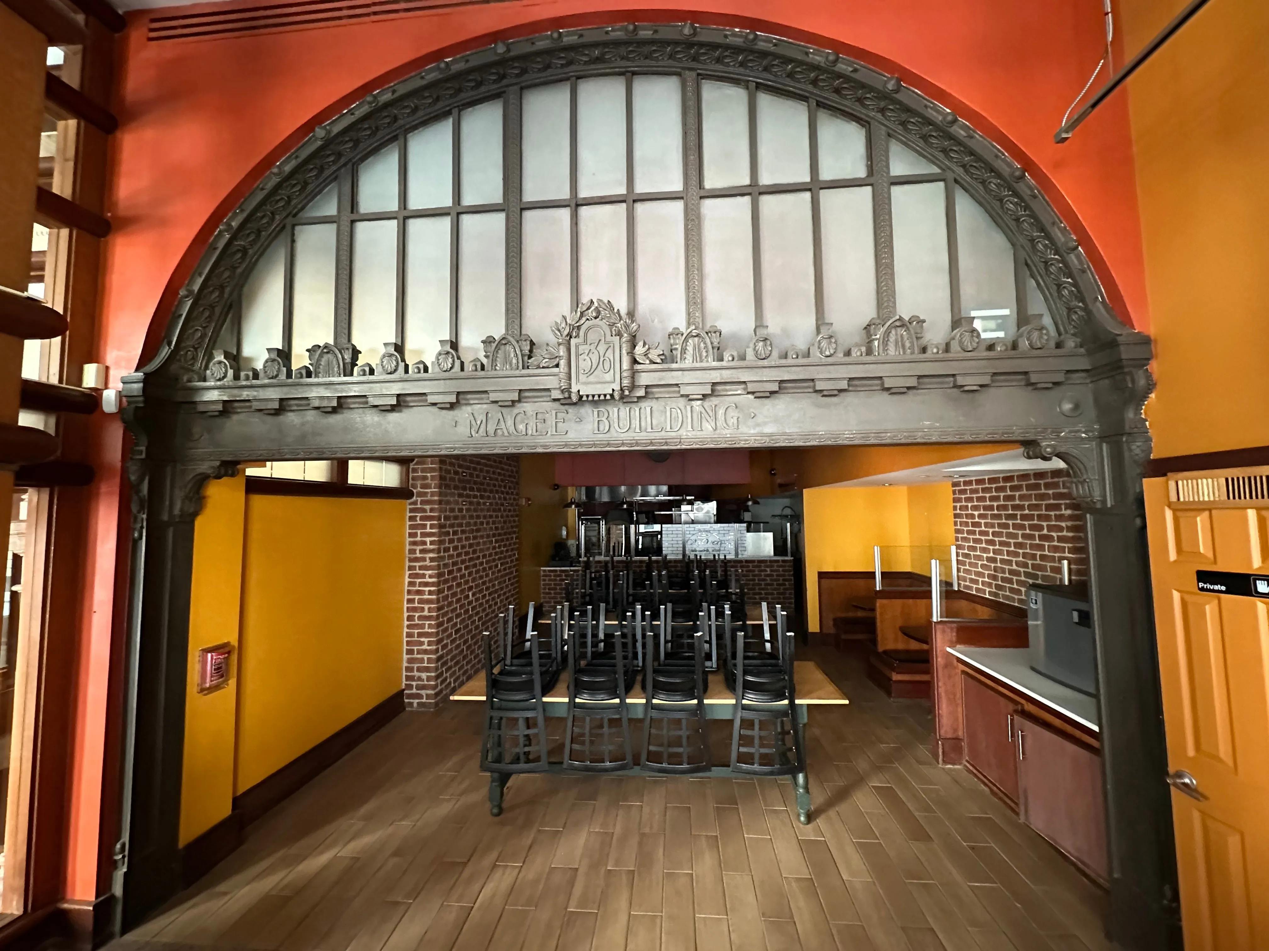 Original bronze entrance arch labeled "Magee Building"