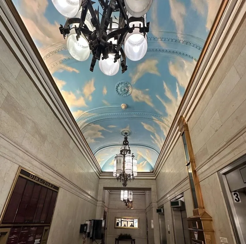 The arched lobby ceiling is now painted with a cloudy blue sky.